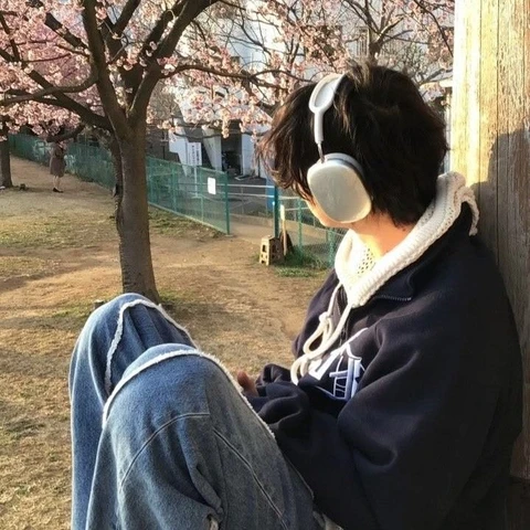 A person sitting on a bench with headphones on.