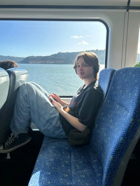A woman sitting on a train looking out the window.