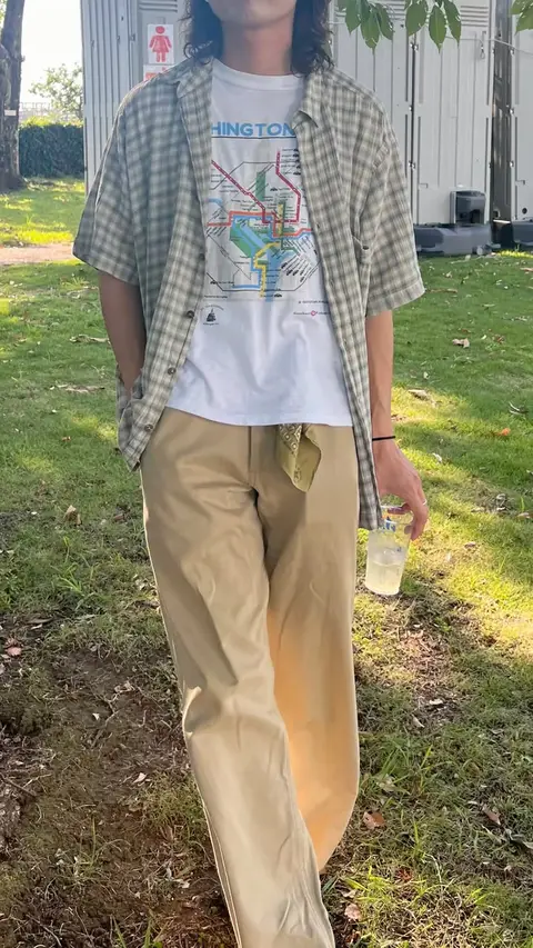 A man in a plaid shirt and khaki pants holding a water bottle.