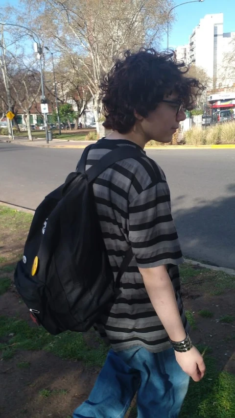 A man with a backpack walking down the street.