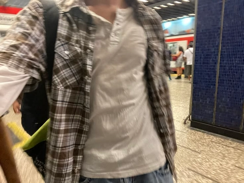 A group of people standing next to each other in a subway station.