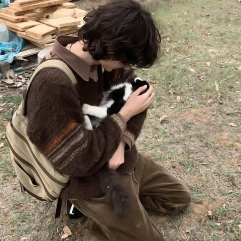 A man holding a small kitten in his arms.