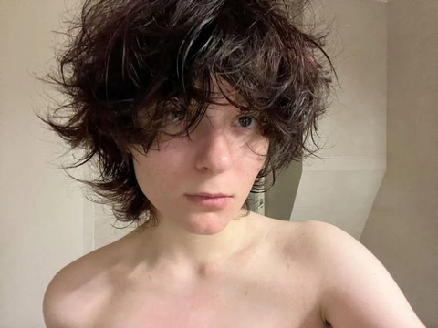 A woman with curly hair is posing for a picture.