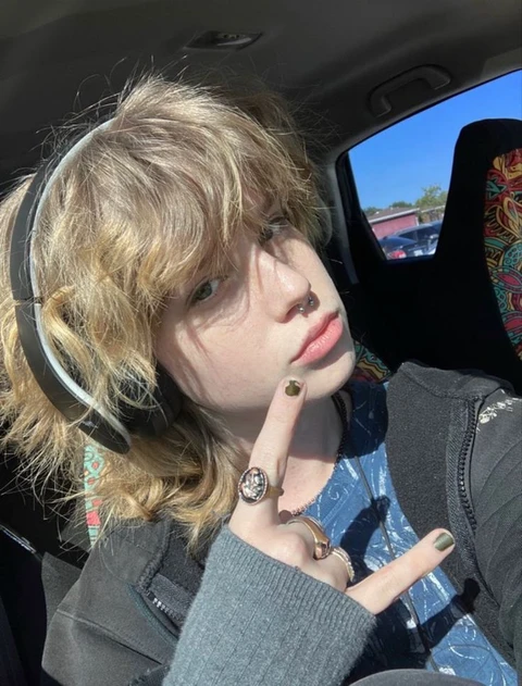 A doll sitting in the back seat of a car.