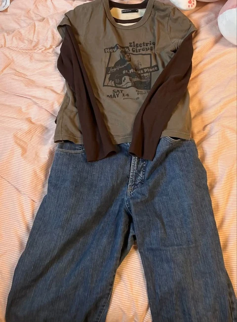 A pair of jeans and a t-shirt on a bed.