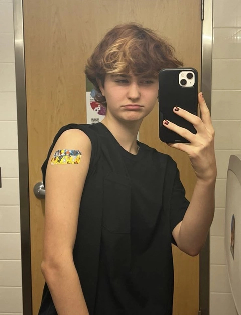 A young man taking a selfie in a bathroom mirror.