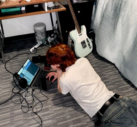 A woman laying on the floor using a laptop computer.