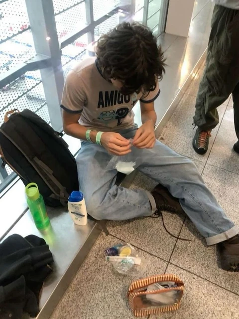 A man sitting on the floor with his feet on the ground.