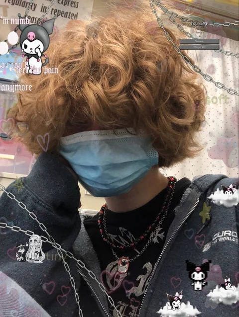 A person with curly hair wearing a surgical mask.
