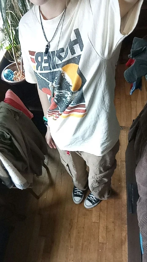 A woman standing in front of a mirror wearing a shirt.