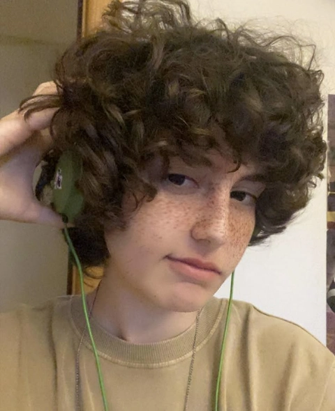 A woman with curly hair is holding a cell phone.