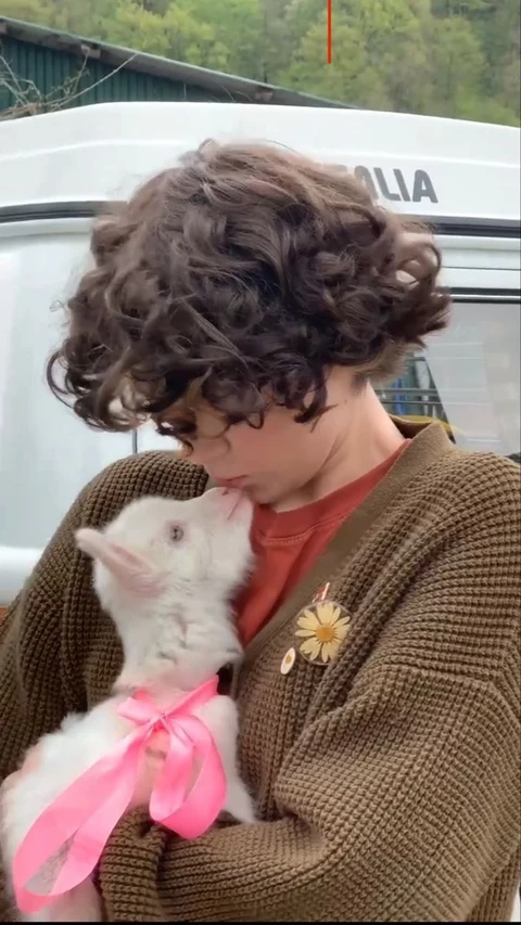 A woman holding a white rabbit in her arms.