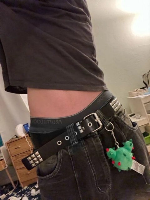 A woman wearing a pair of jeans with a green frog on it.