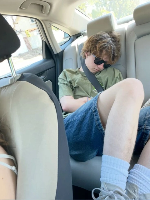 A man and a woman sitting in the back seat of a car.