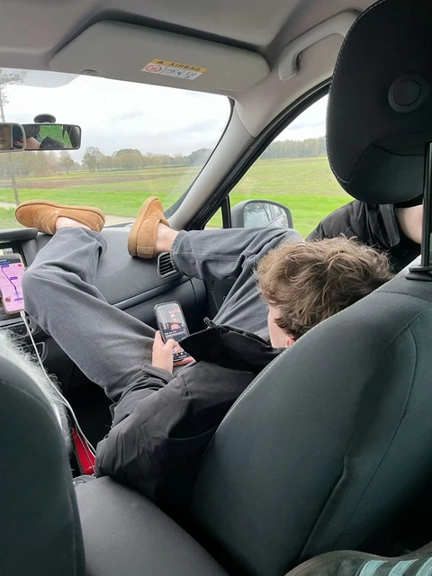 A couple of people sitting in the back seat of a car.