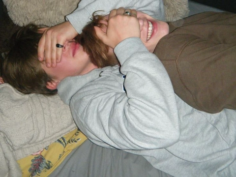 A couple of people laying on top of each other.