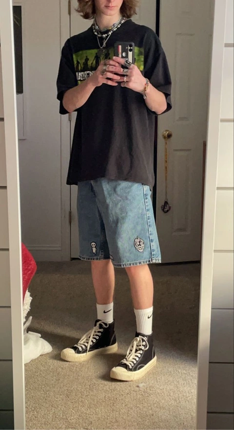 A man standing in front of a mirror holding a cell phone.