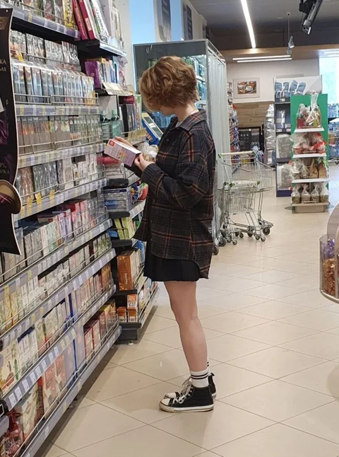 A woman standing in front of a store filled with cds.