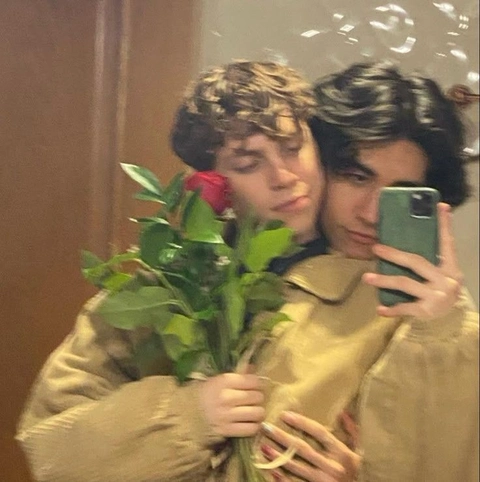 A group of young men taking a selfie with a bouquet of flowers.