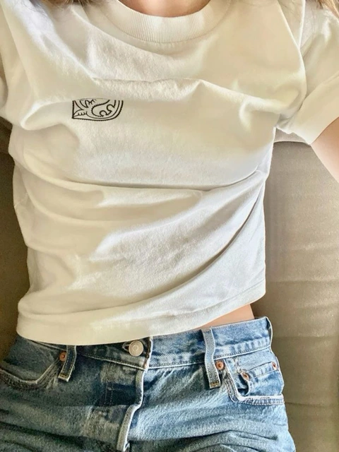 A woman wearing a white shirt and blue jeans.