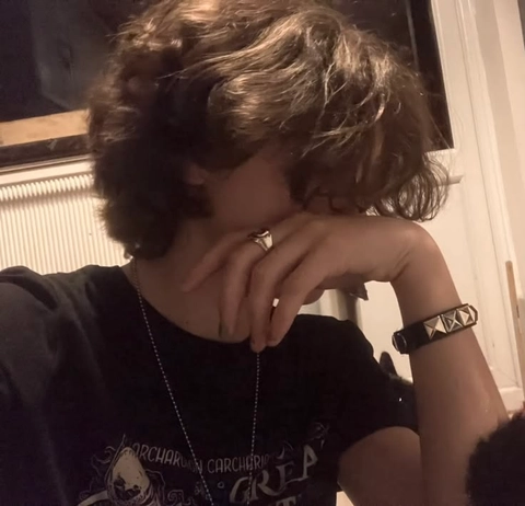A woman with her hands on her face in front of a mirror.