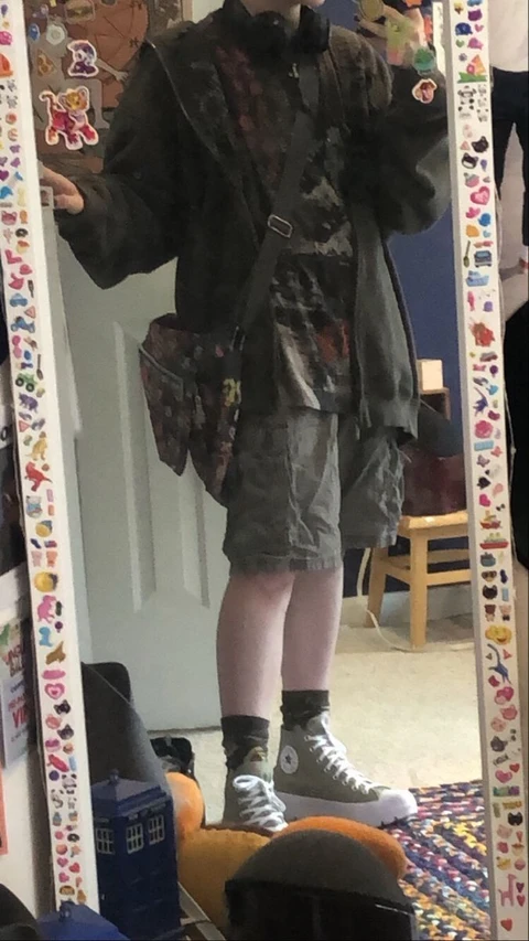 A mannequin dressed in a camouflage outfit standing in front of a mirror.