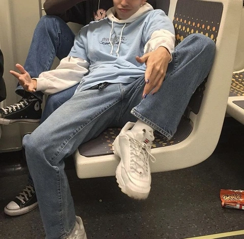 A man sitting on a bus with his feet up in the air.