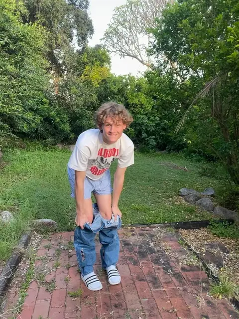 A man standing on top of a brick walkway in a park.