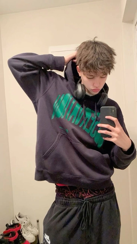 A young man taking a selfie in front of a mirror.