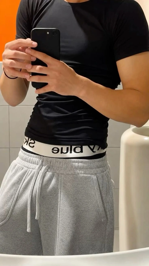 A woman taking a selfie in a bathroom mirror.