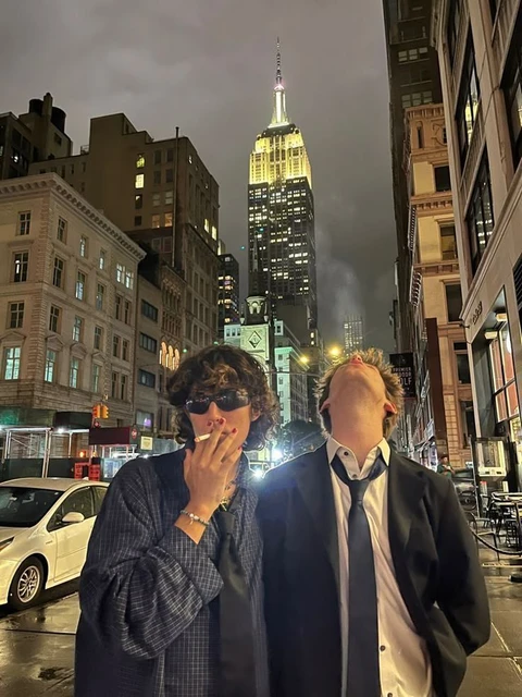 A couple of people standing in the middle of a city.