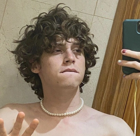 A man with curly hair is taking a selfie.