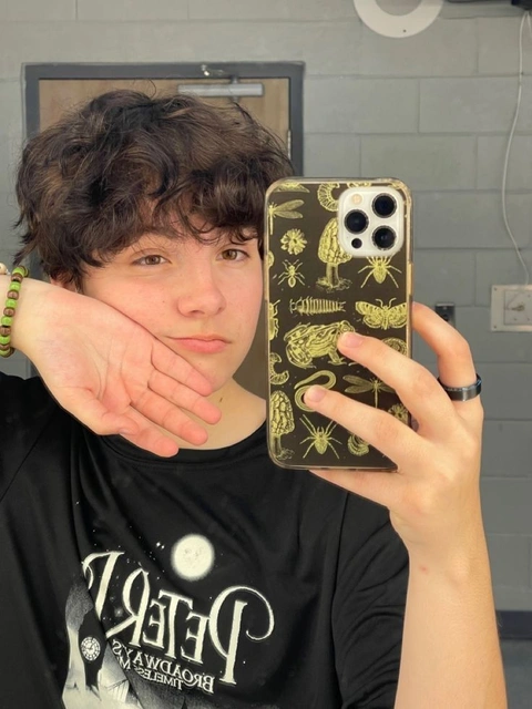 A young man holding up a phone case with a picture of a man on it.
