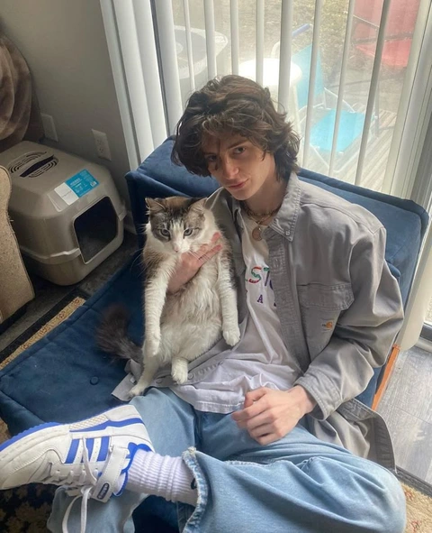 A man sitting on a couch holding a cat.