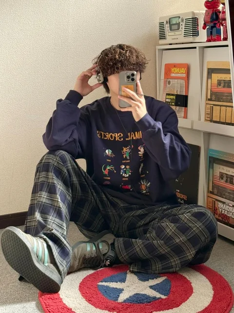 A man sitting on the floor taking a picture of himself.