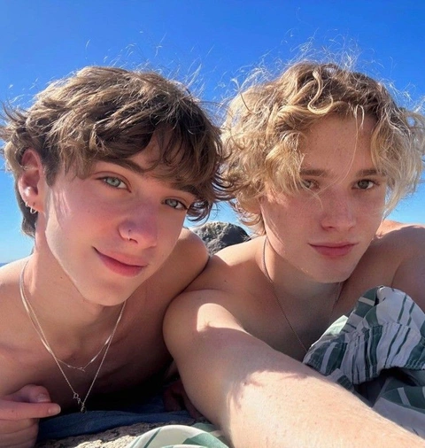 A group of young men laying on top of a beach.