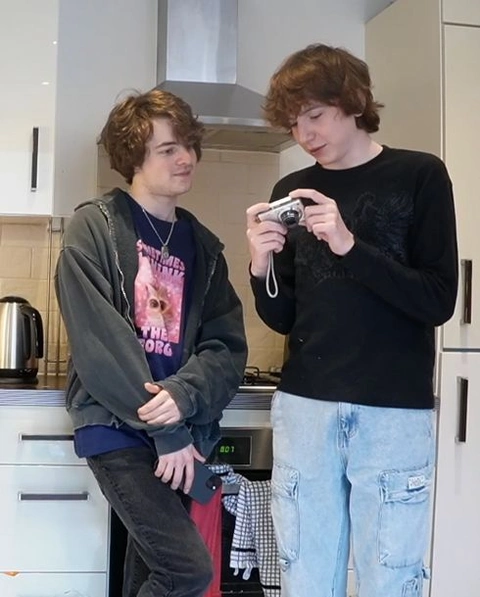 A group of young men standing next to each other in a kitchen.