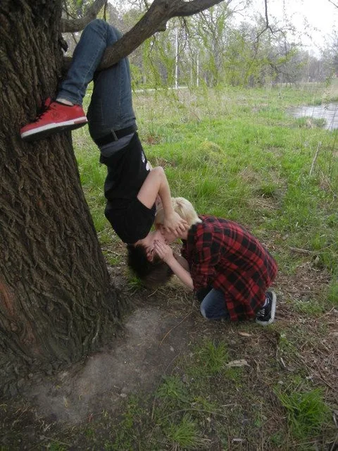 A couple of people that are standing next to a tree.
