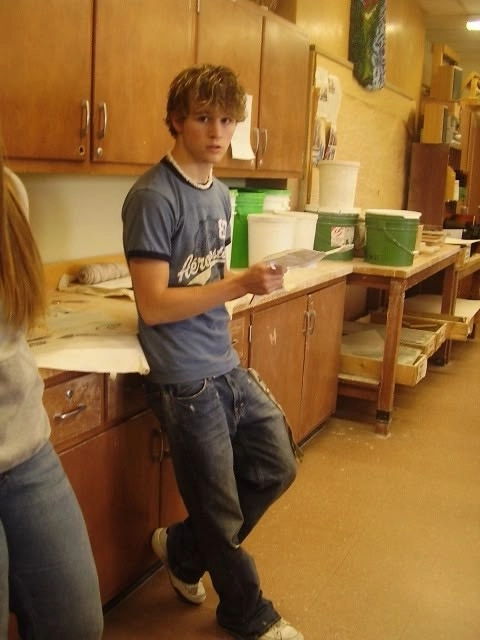 A young boy standing in a kitchen next to a counter.