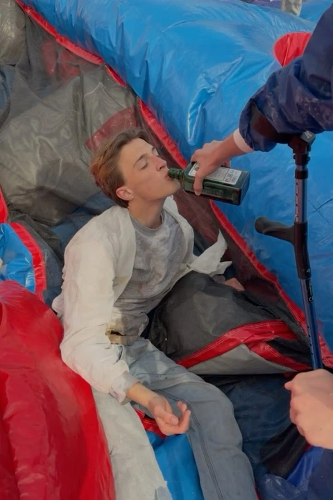 A man sitting on top of a giant inflatable slide.