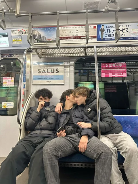 A group of people sitting on top of a subway train.