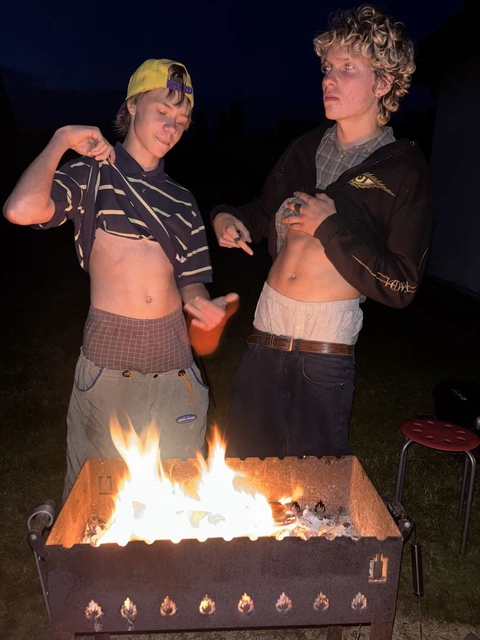 A group of people standing around a fire pit.