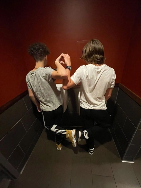 A couple of people standing in front of a mirror.