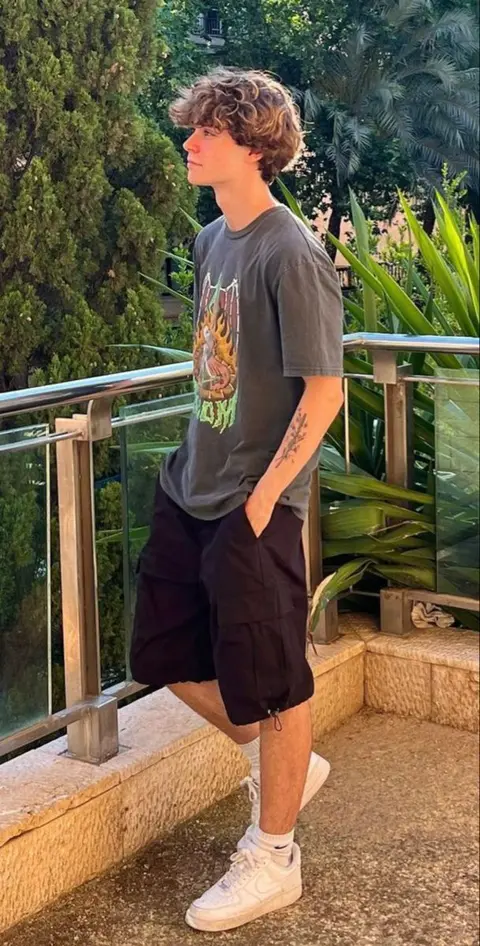 A young man standing on a set of stairs.