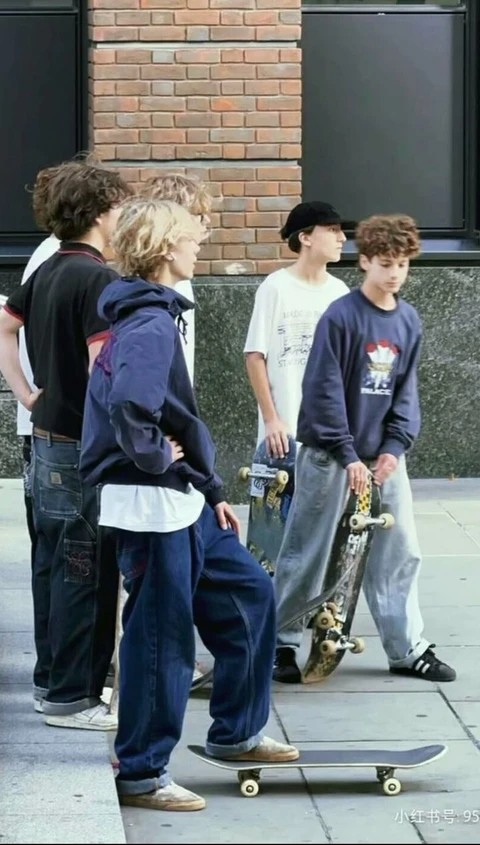 A group of young men standing next to each other on skateboards.