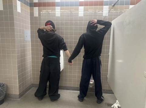 A group of people standing in a bathroom next to each other.