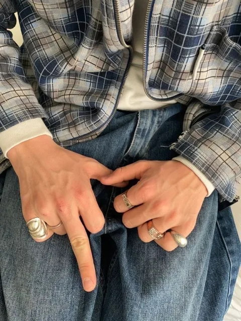 A close up of a person's hands with rings on them.