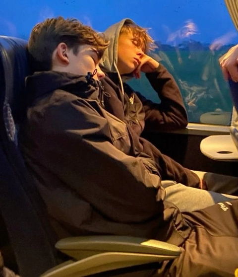A couple of people sitting on top of a bus.