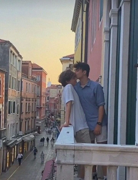 A couple of people standing on top of a balcony.