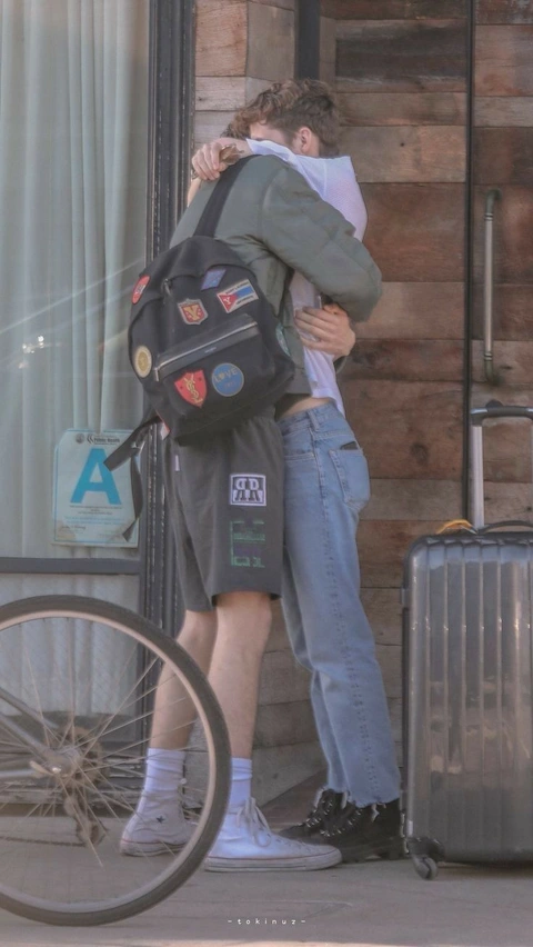 A couple of people standing next to each other in front of a building.